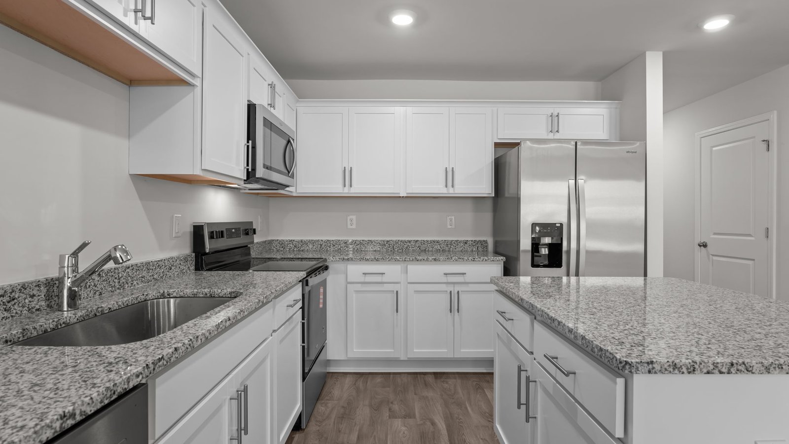 large kitchen island with white cabinets and stainless steel appliances