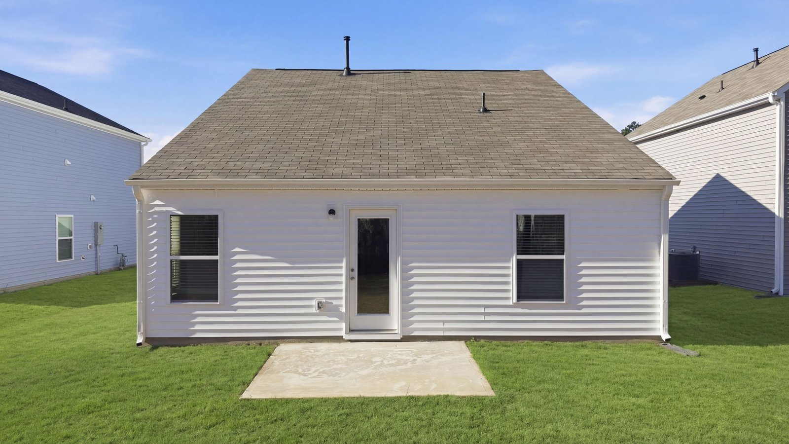 Rear image of the home with back yard and patio pad