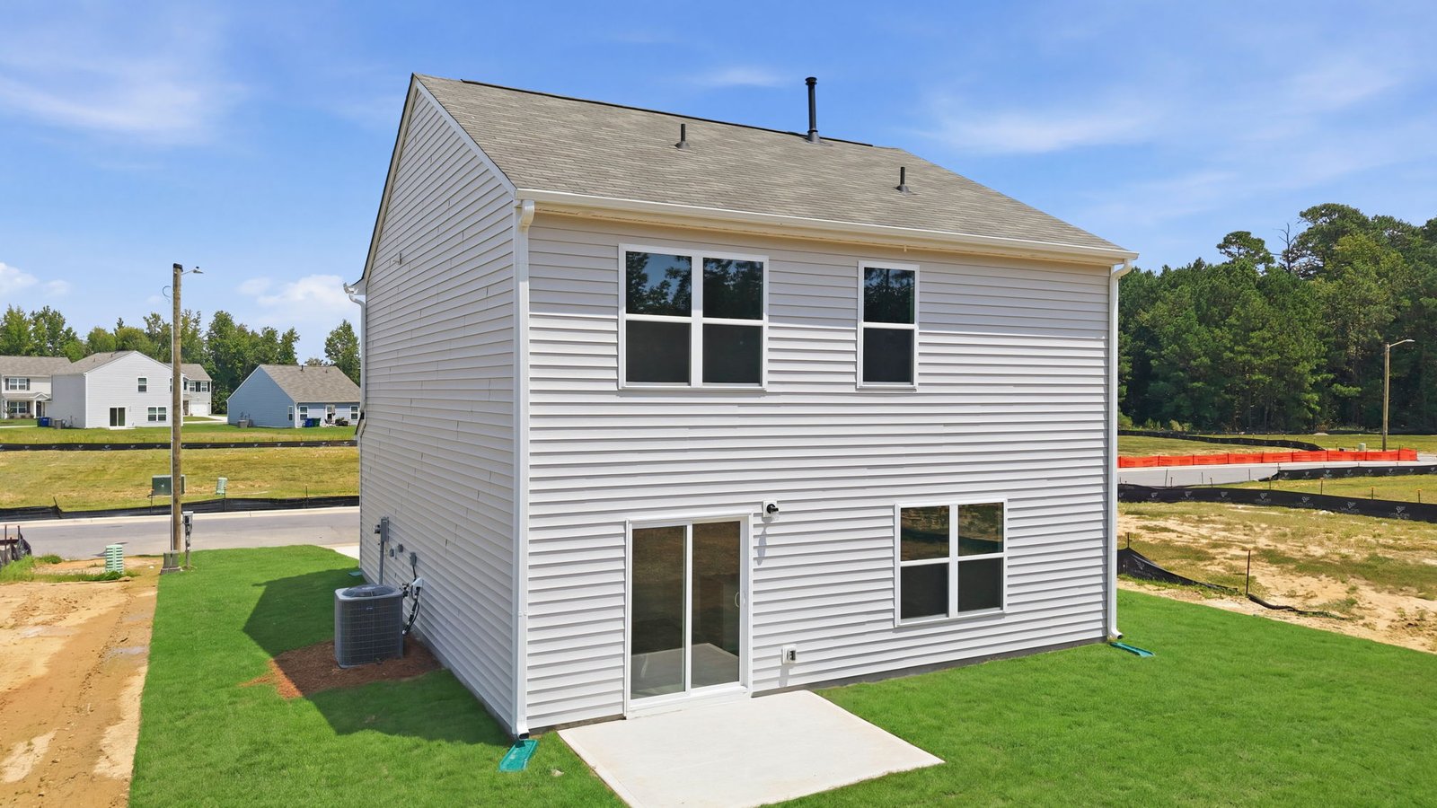 rear view of home with yard and back patio pad