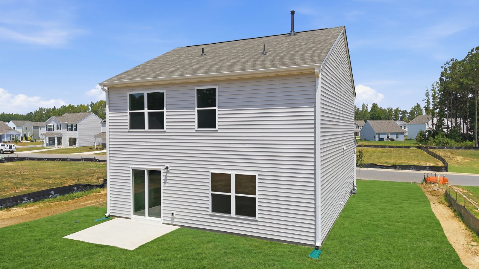 rear view of home with yard and back patio pad
