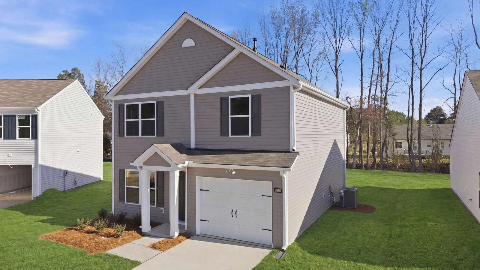 Two story home with brown vinyl and attached garage