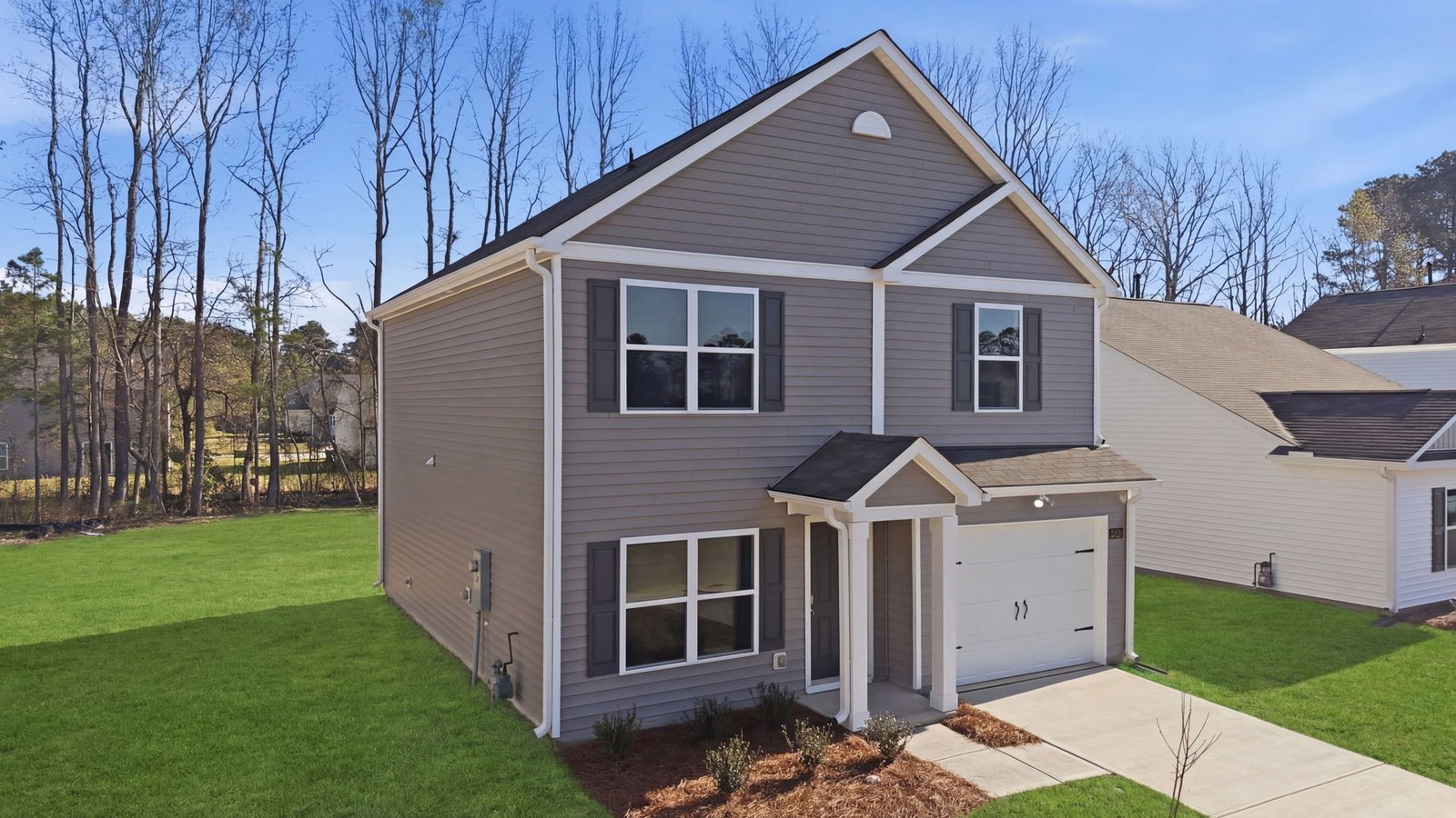 View of two story home with covered front door and attached garage