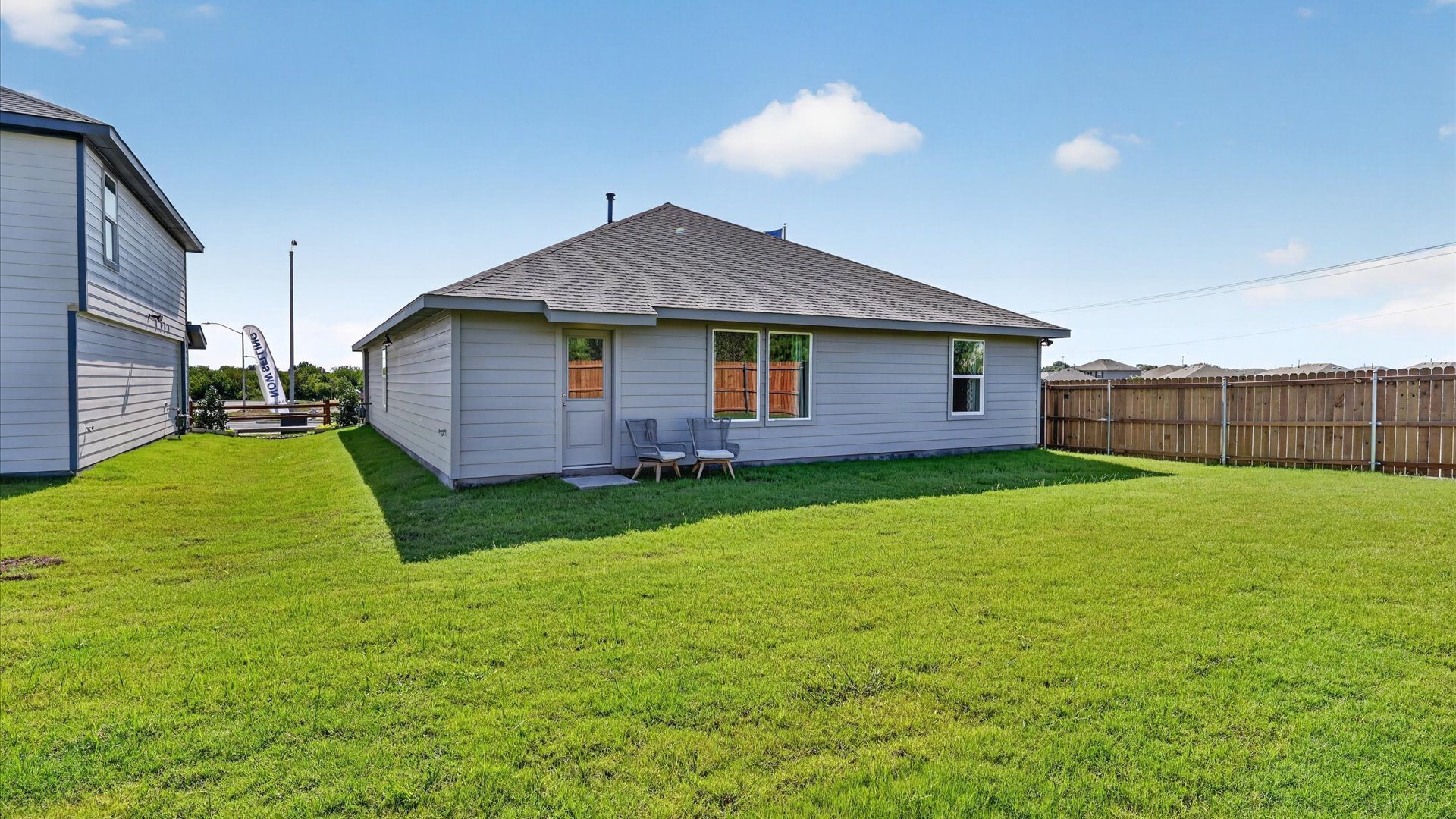 Covered back stoop overlooking spacious backyard
