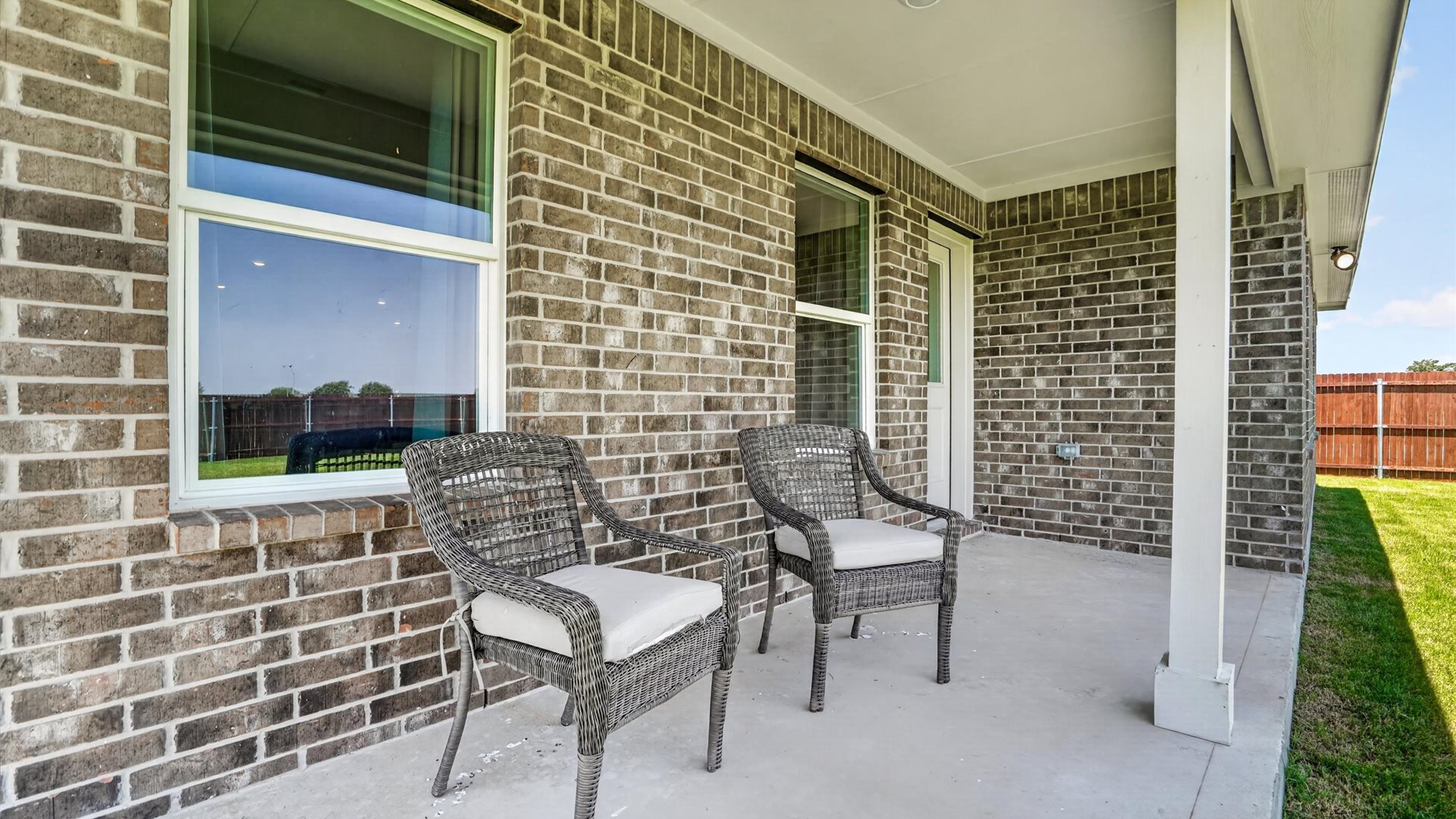 Covered back patio overlooking spacious backyard