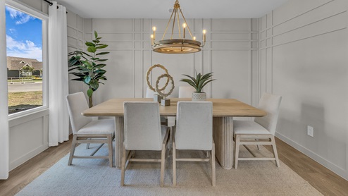 Dining room and living room with vinyl flooring and 2 windows.