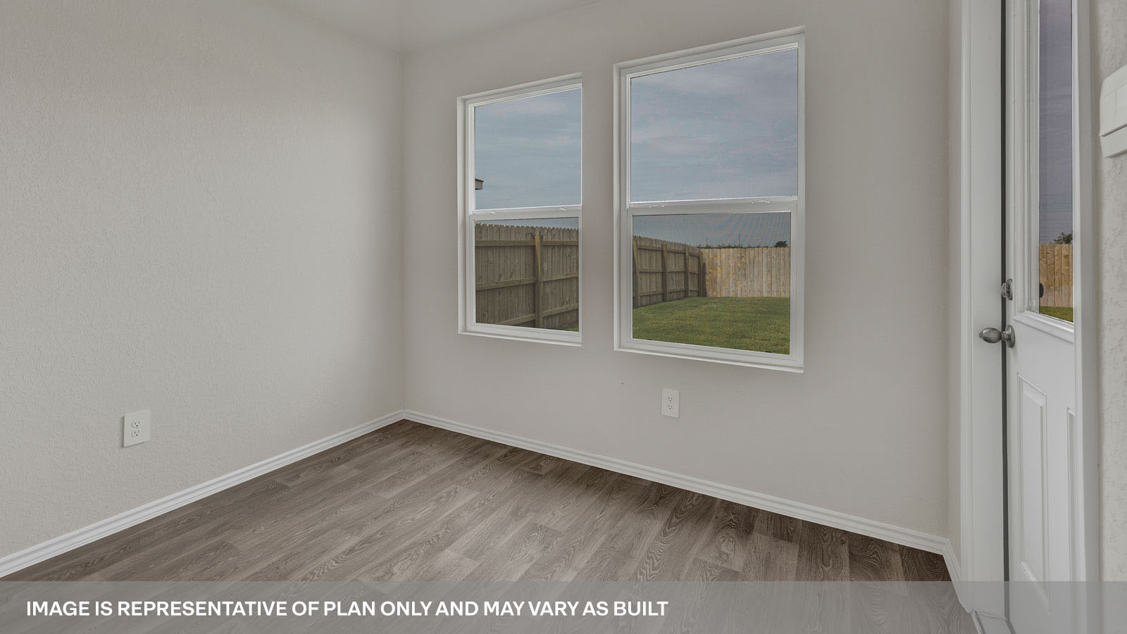 Dining room with vinyl flooring, 2 windows, and a half lite exterior door.
