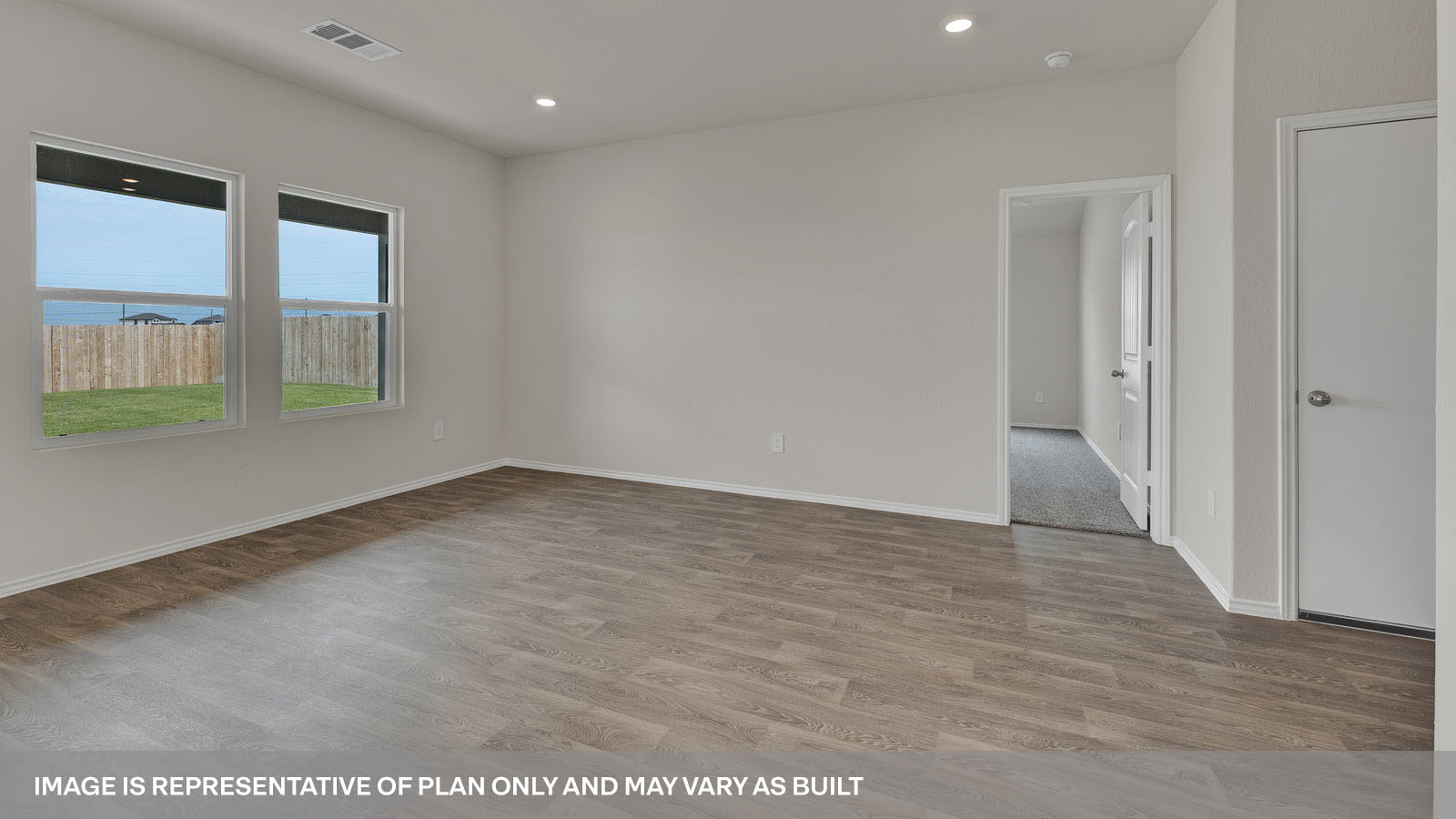Living room with vinyl flooring and two windows.