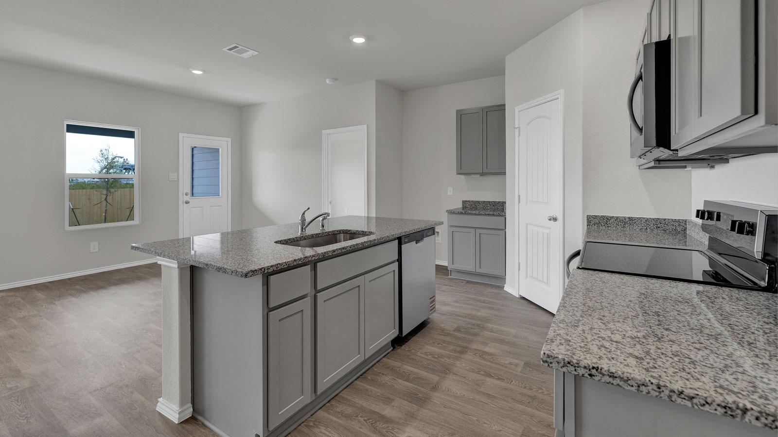 Kitchen with kitchen island and grey cabinets.
