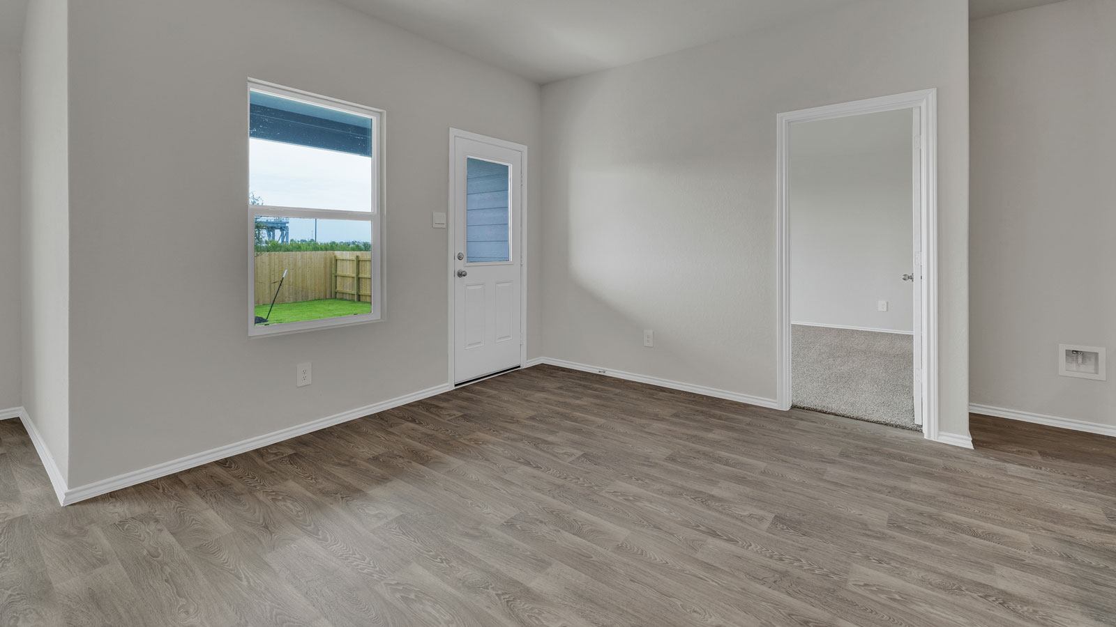 Dining room with vinyl flooring, 2 windows, and a half lite exterior door.