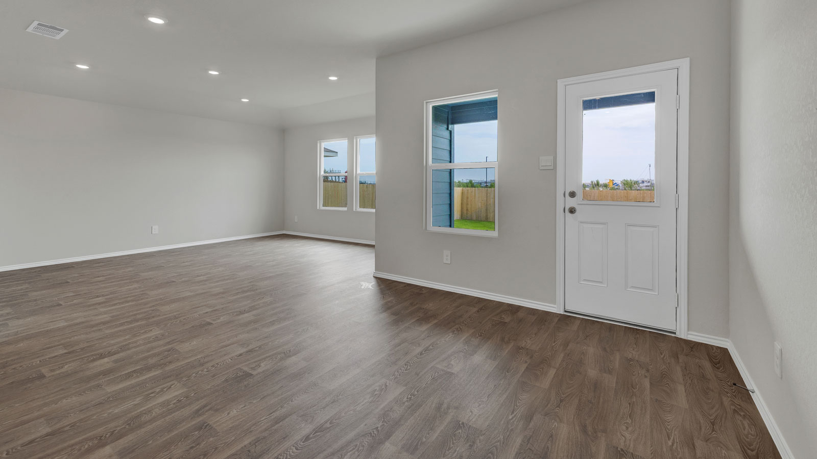 Dining room with vinyl flooring, 2 windows, and a half lite exterior door.