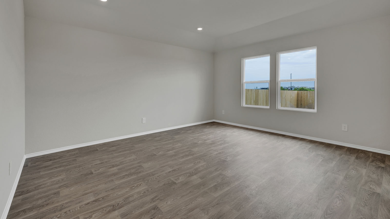 Living room with vinyl flooring and 2 windows.