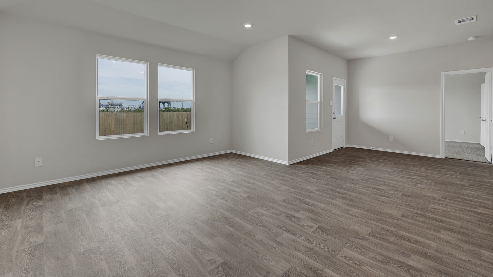 Living room with vinyl flooring and 2 windows.