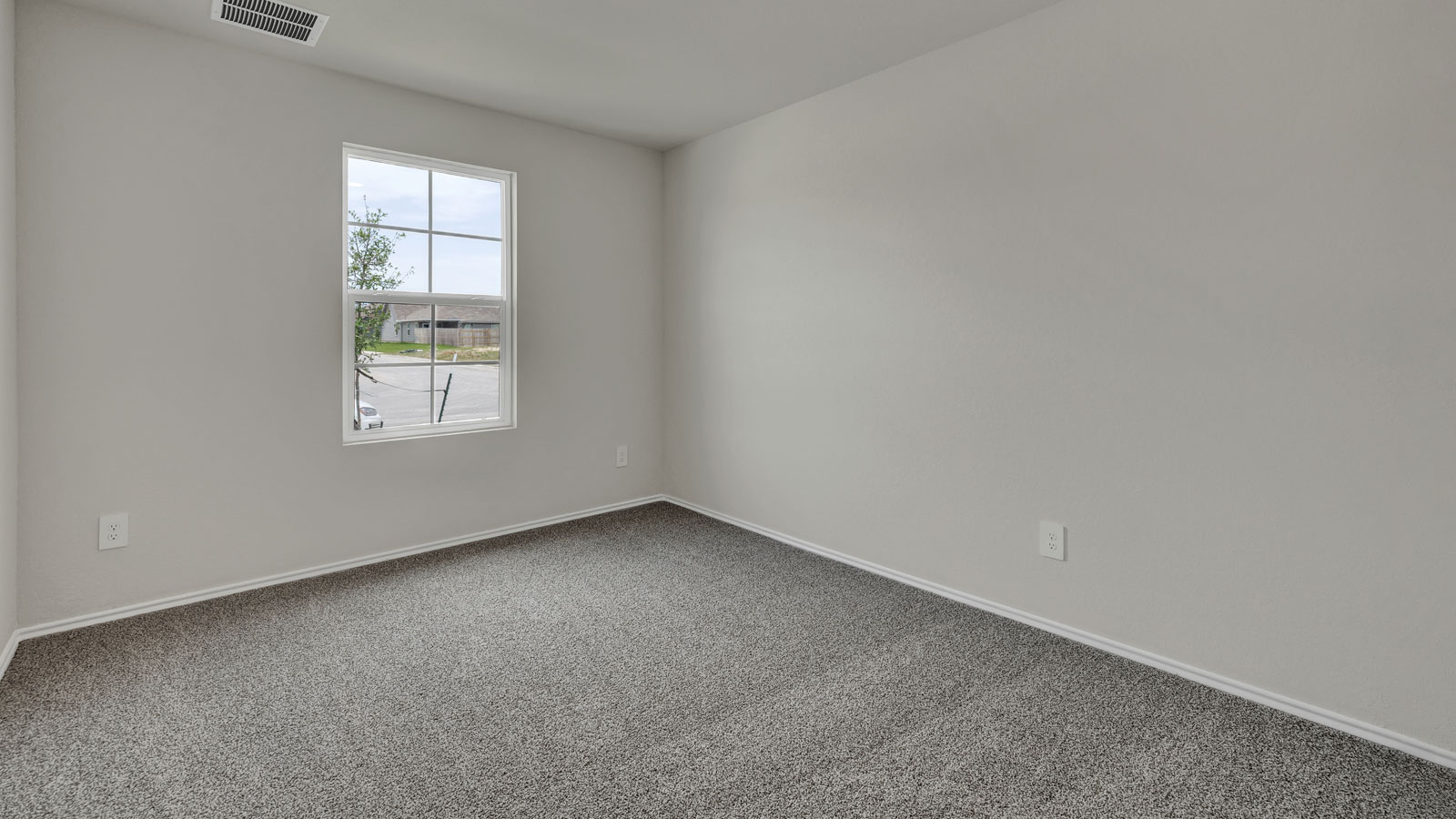Front bedroom with carpeting and one window.