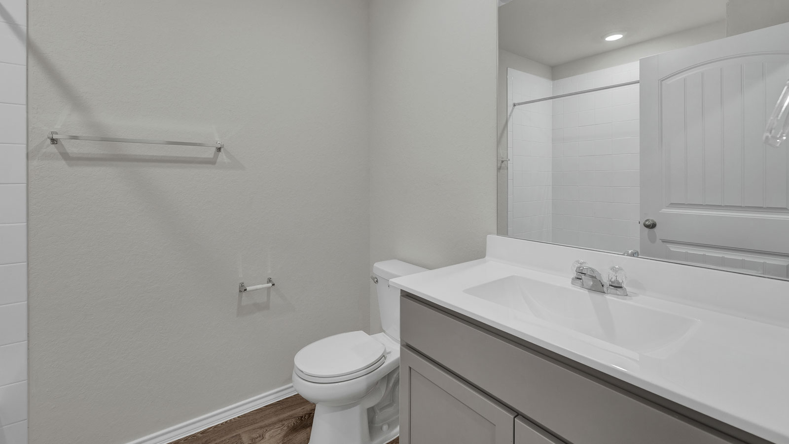 Bathroom with single sink vanity, toilet and tub.