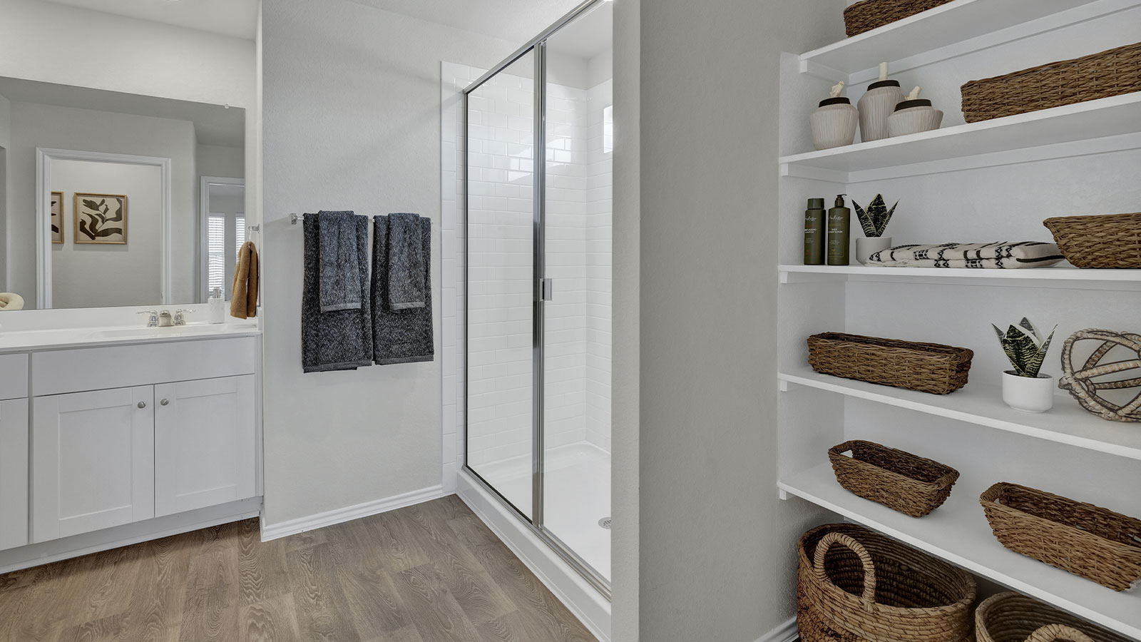 Main bathroom with wooden shelving, vanity, and walk-in shower.