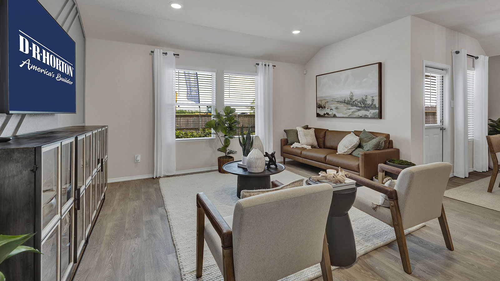 Living room with vinyl flooring and two windows.