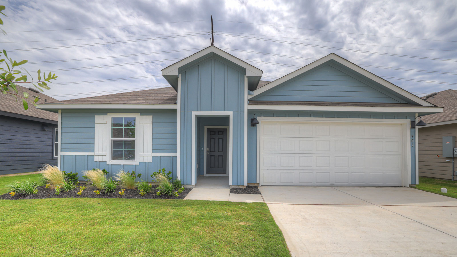 Single-story farmhouse exteriors with one windows and 2 garage door.