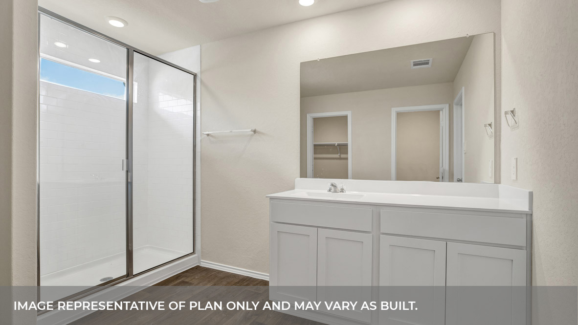 Main bathroom with vanity and walk-in shower with glass door.