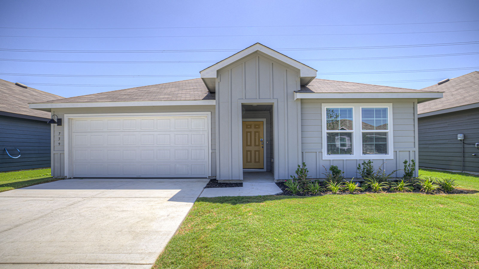 Single-story farmhouse exteriors with a 2 car garage and two windows.
