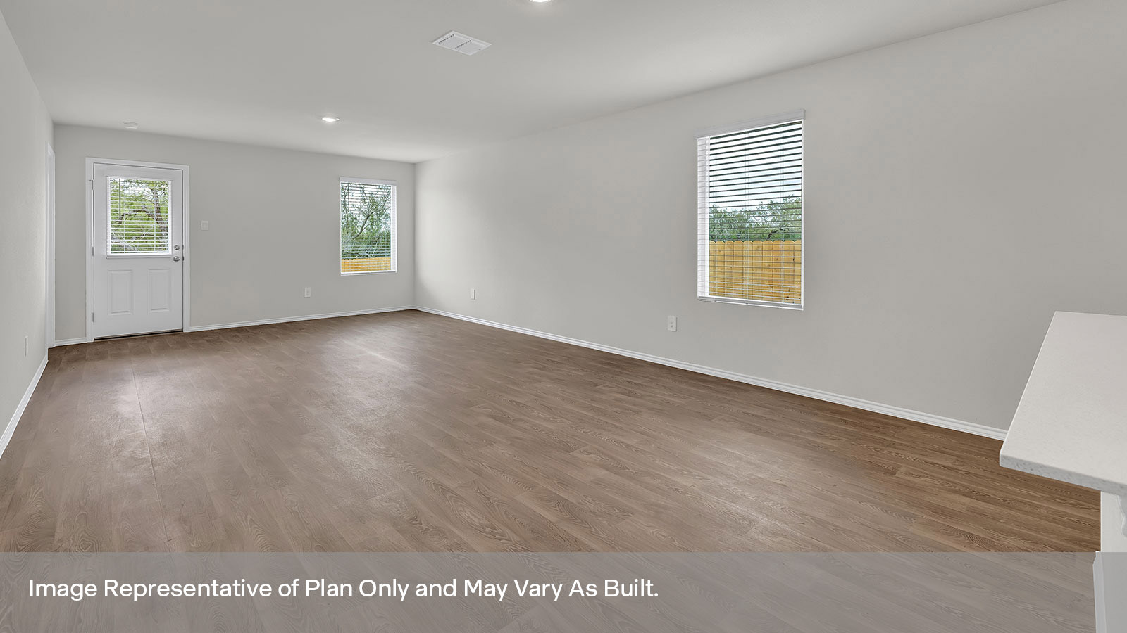 Dining room and living room with vinyl flooring and two windows.