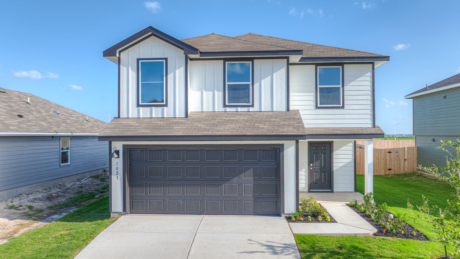 Two-story farmhouse exterior photo with 2 car garage.