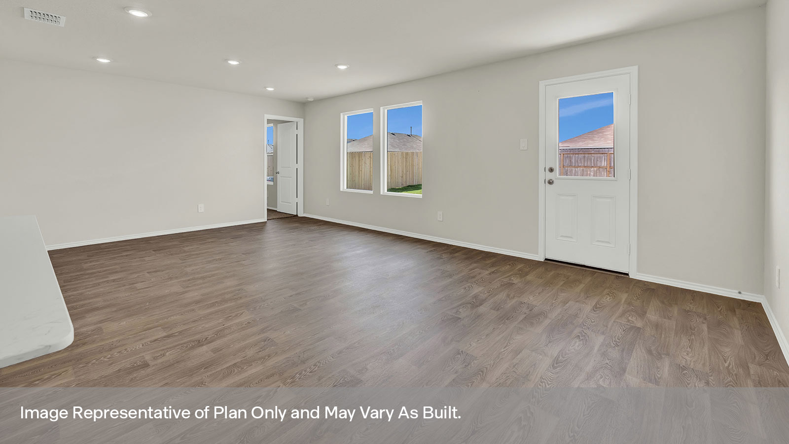Dining room and living room with vinyl flooring, two windows, and a half lite exterior door.