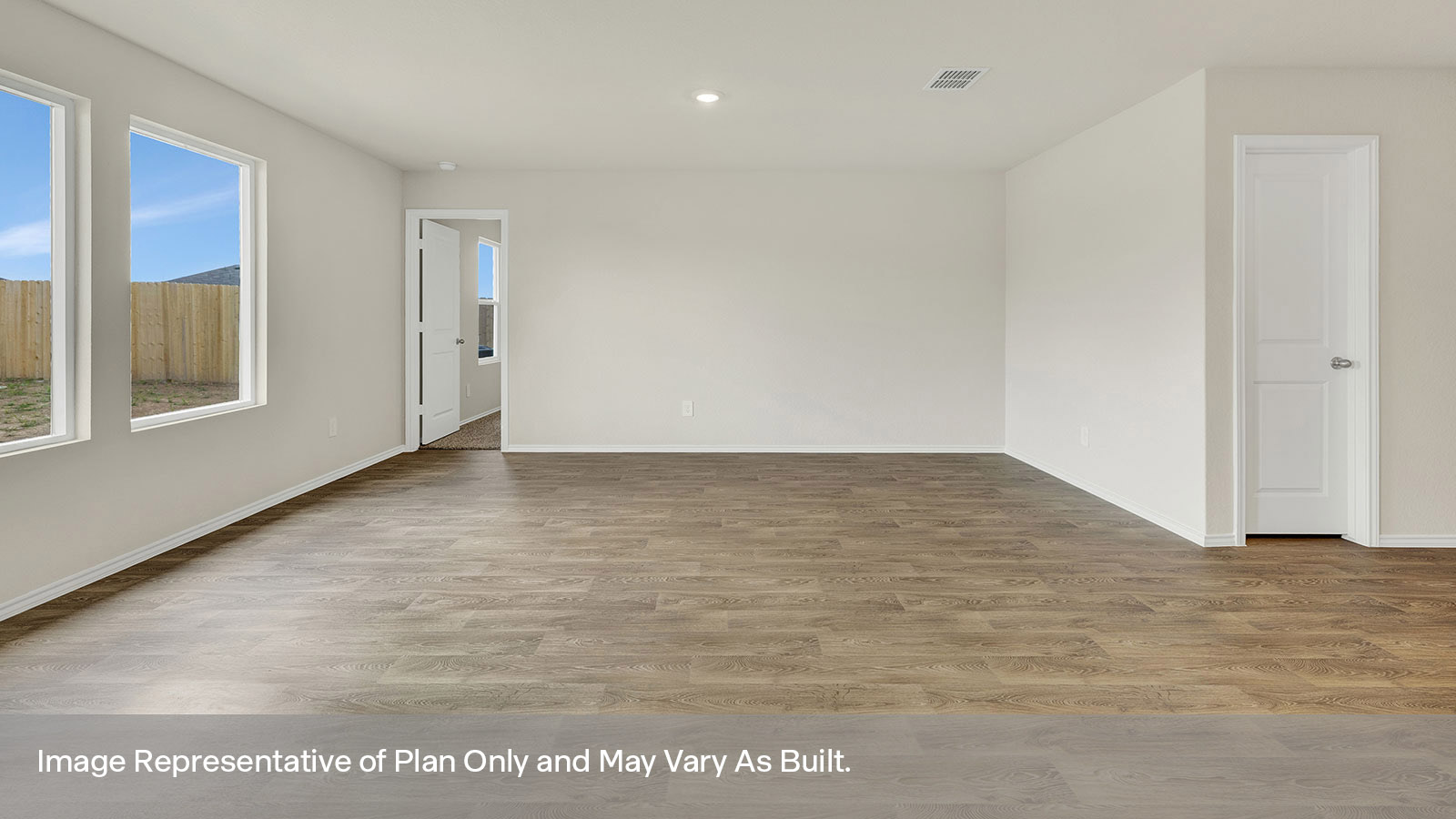 Living room with vinyl flooring and two windows.