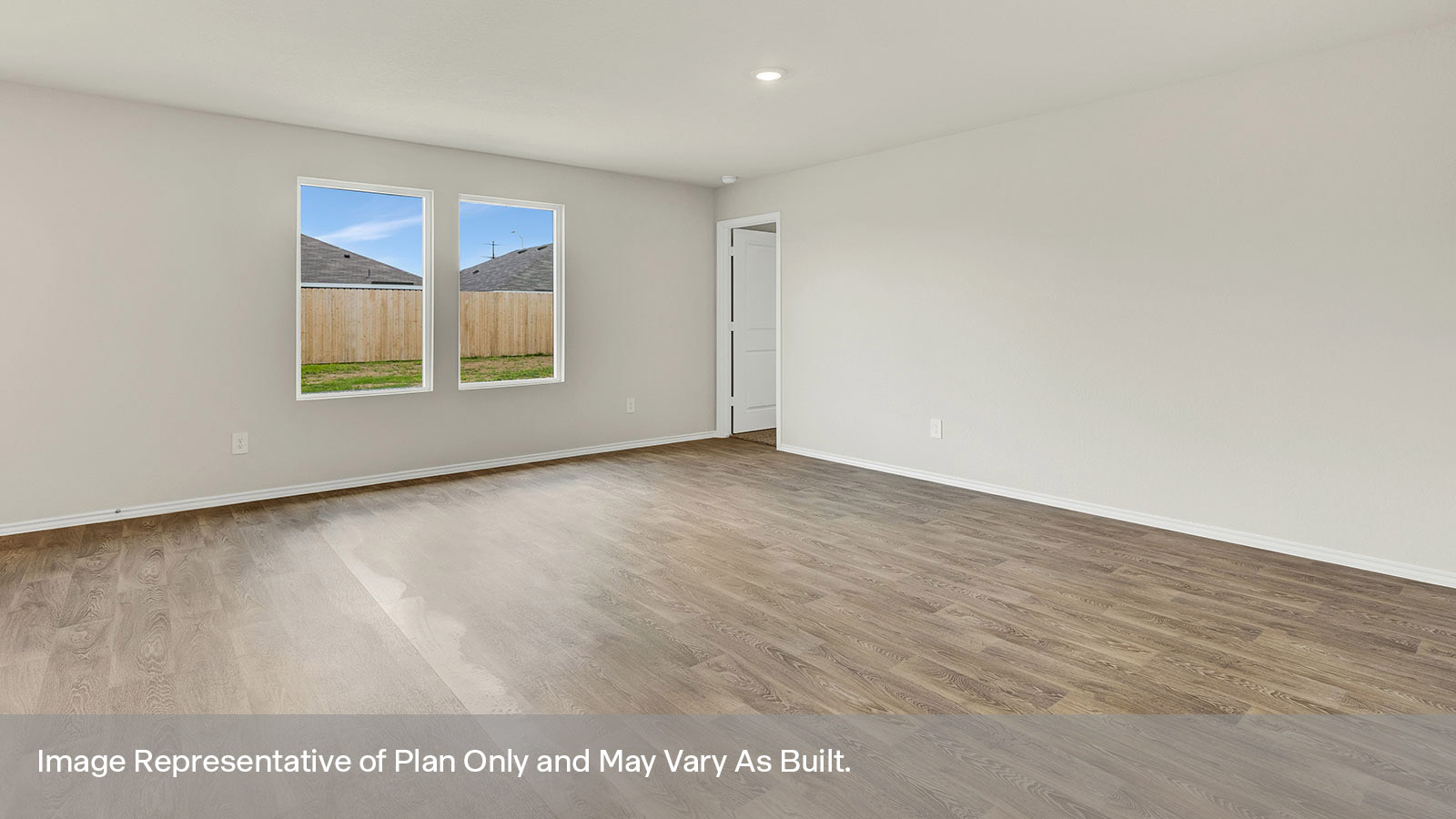 Living room with vinyl flooring and two windows.