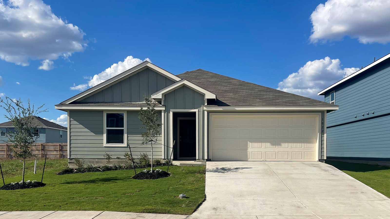 Single-story farmhouse exteriors with one window and a 2 car garage.