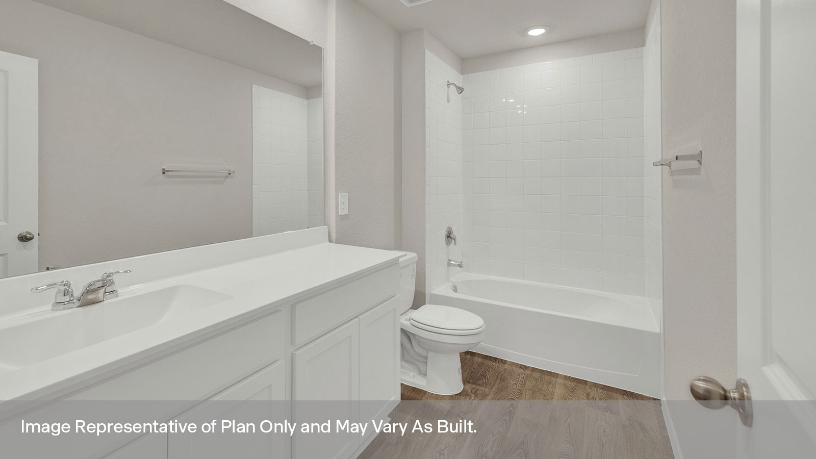 Hall bathroom with vanity, toilet, tub with tile surround.