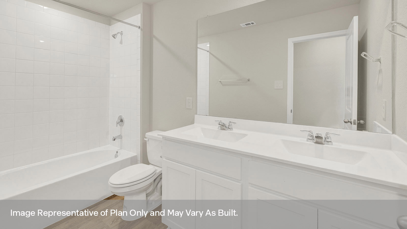 Hall bathroom with dual sink vanity, toilet, and shower/tub.