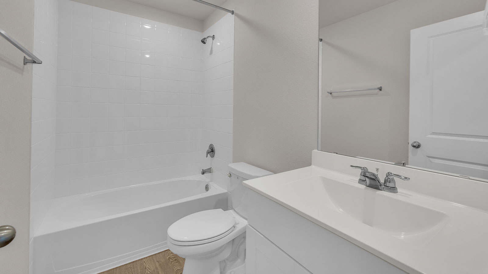Hall bathroom with tub with tile surround, toilet, and single-vanity sink.