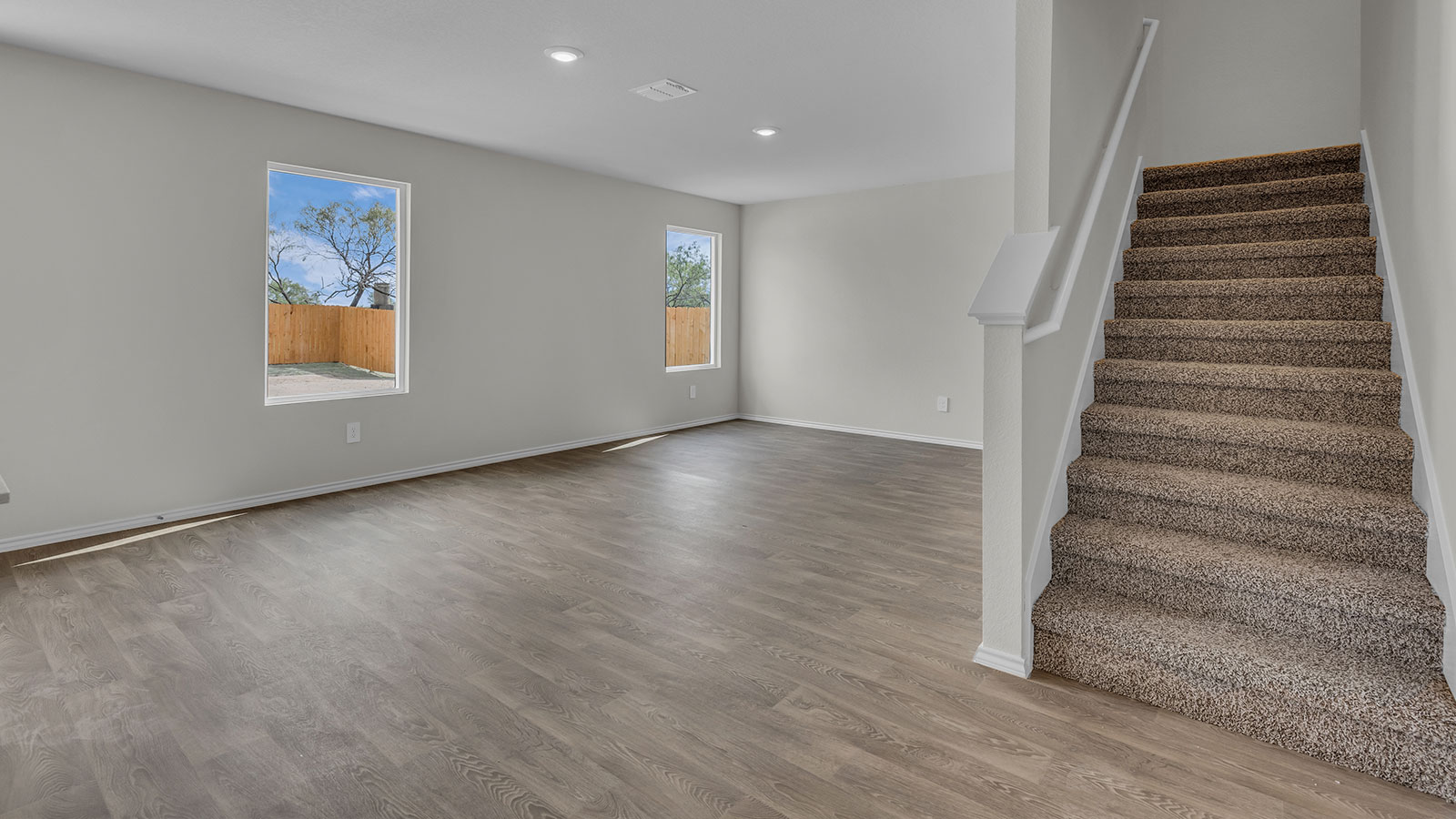 Living room with vinyl flooring opening to the kitchen.
