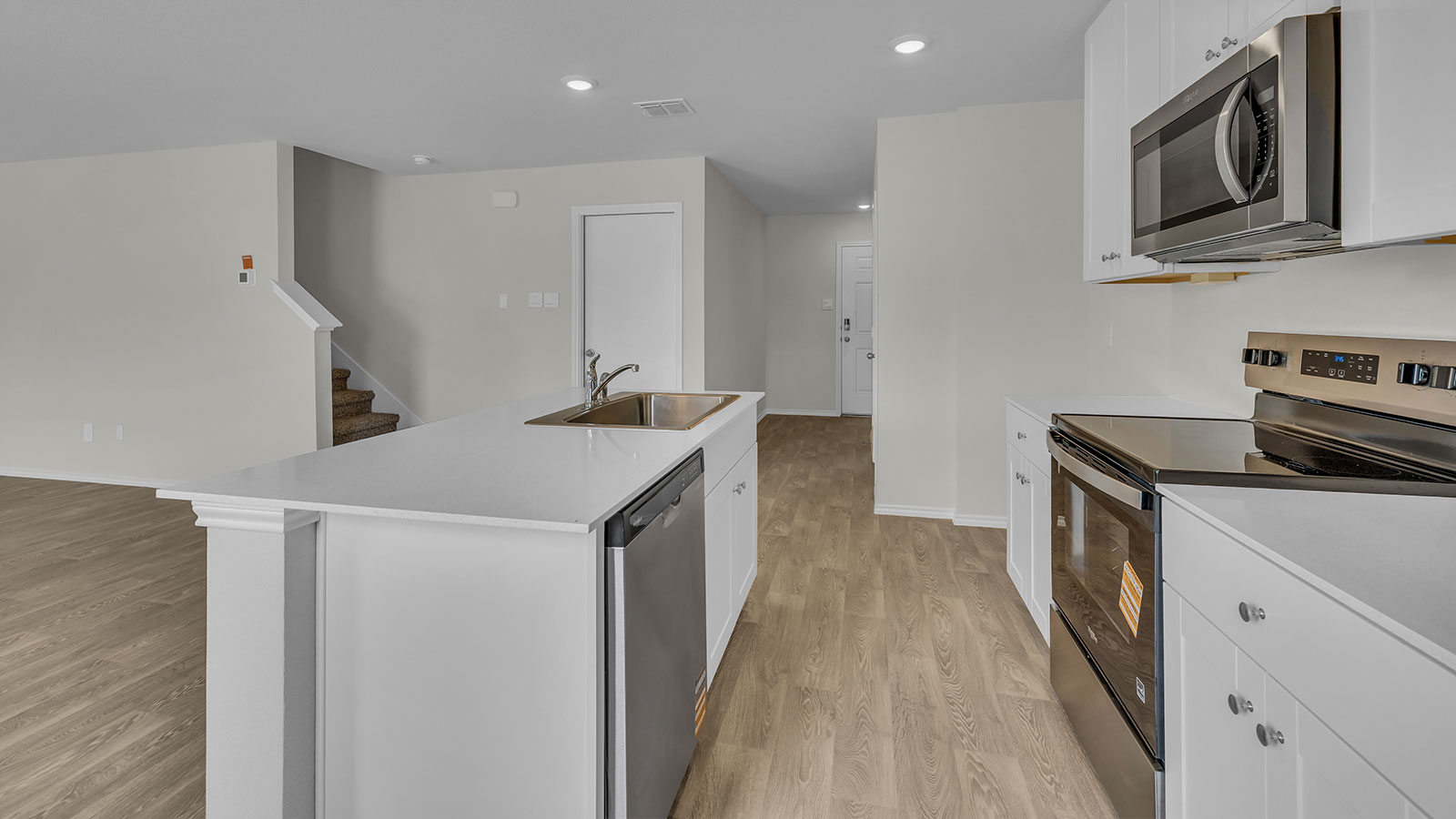 Kitchen with kitchen island and stainless steel sink.