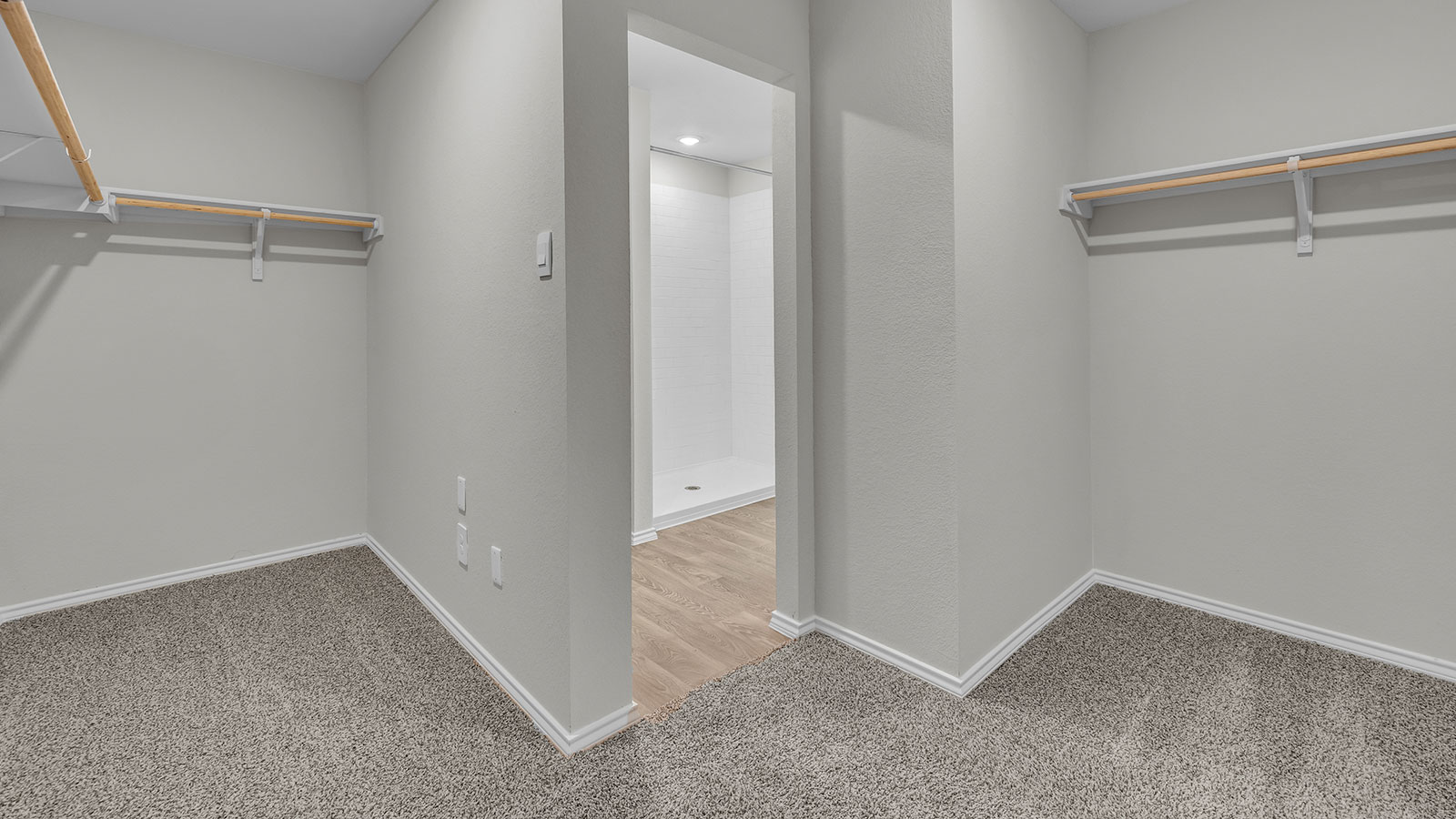 Main bedroom closet with carpeting and wooden shelving.