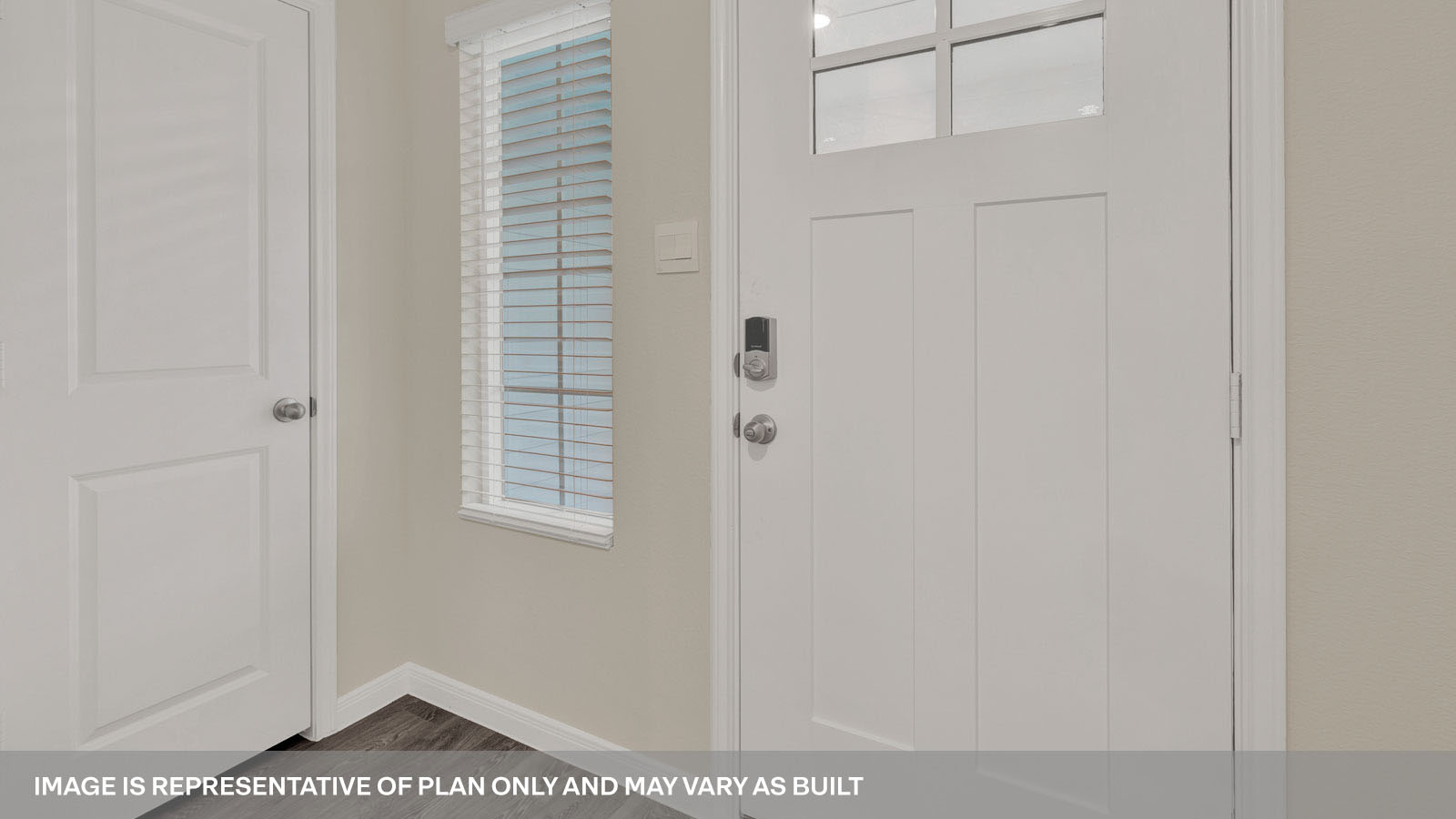 front entry way of home featuring brown flooring and beige walls