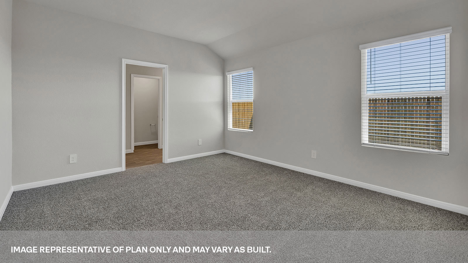 Main bedroom with carpeting and two windows.