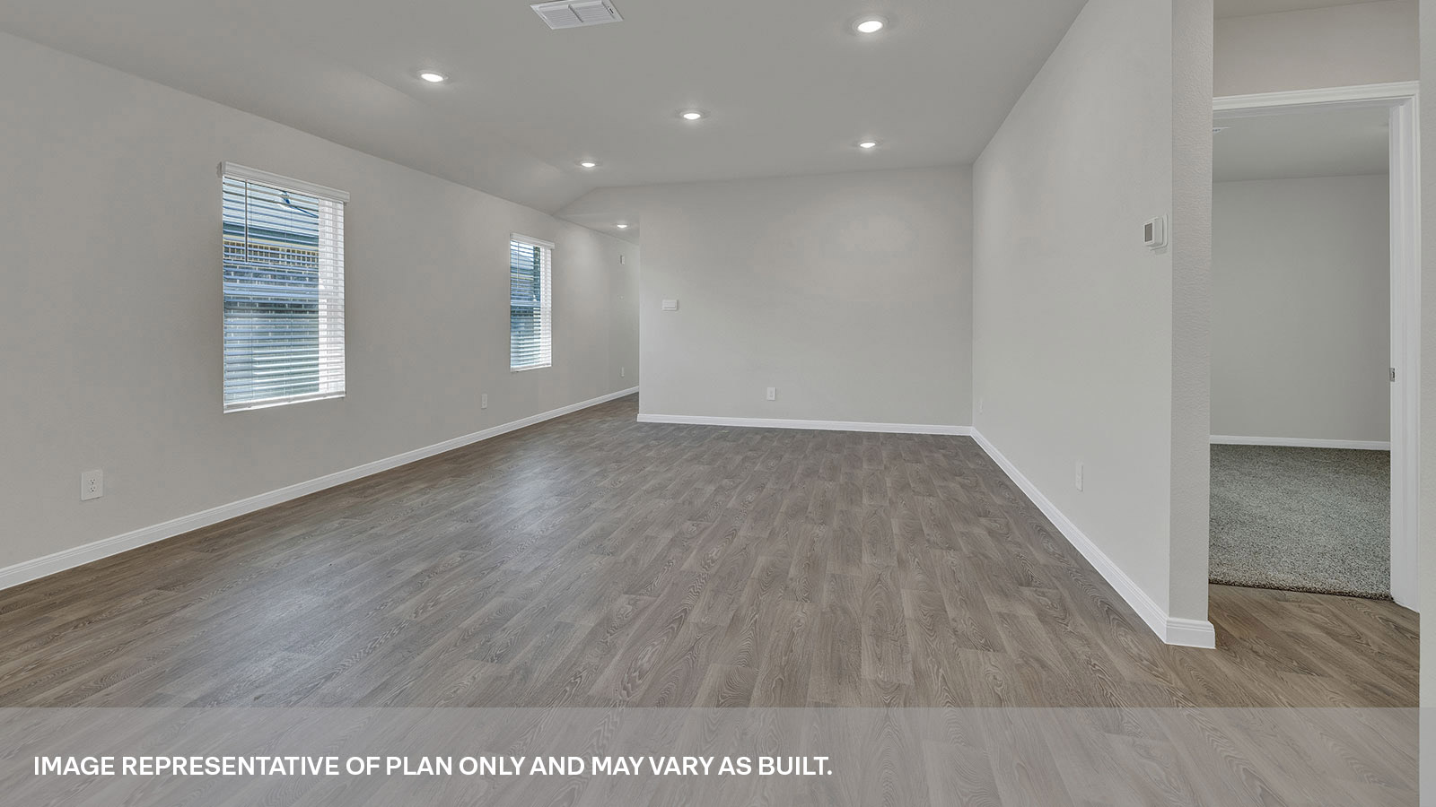 Dining room and living room with vinyl flooring and 2 windows.