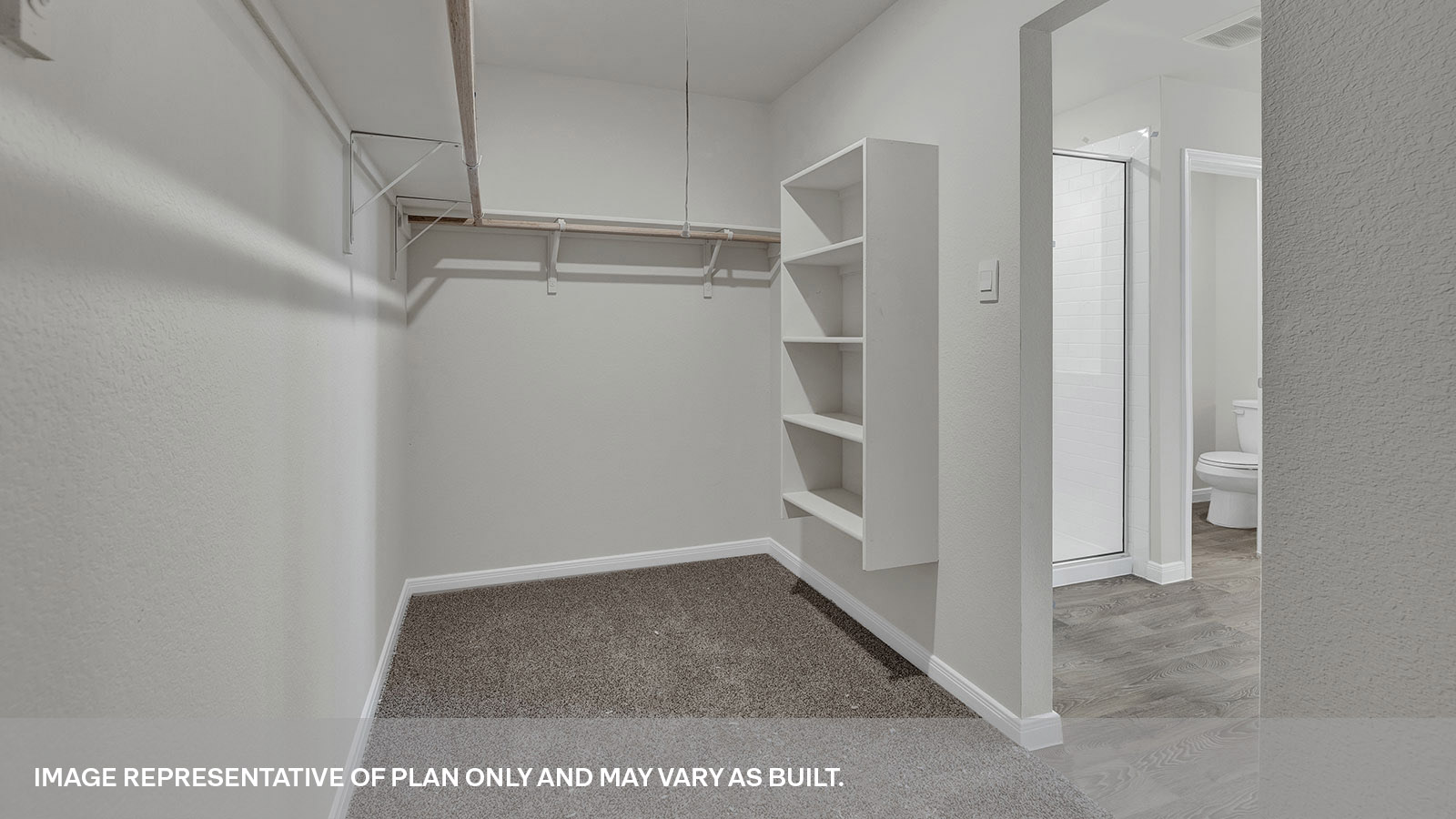 Main bedroom closet with carpeting and wooden shelving.