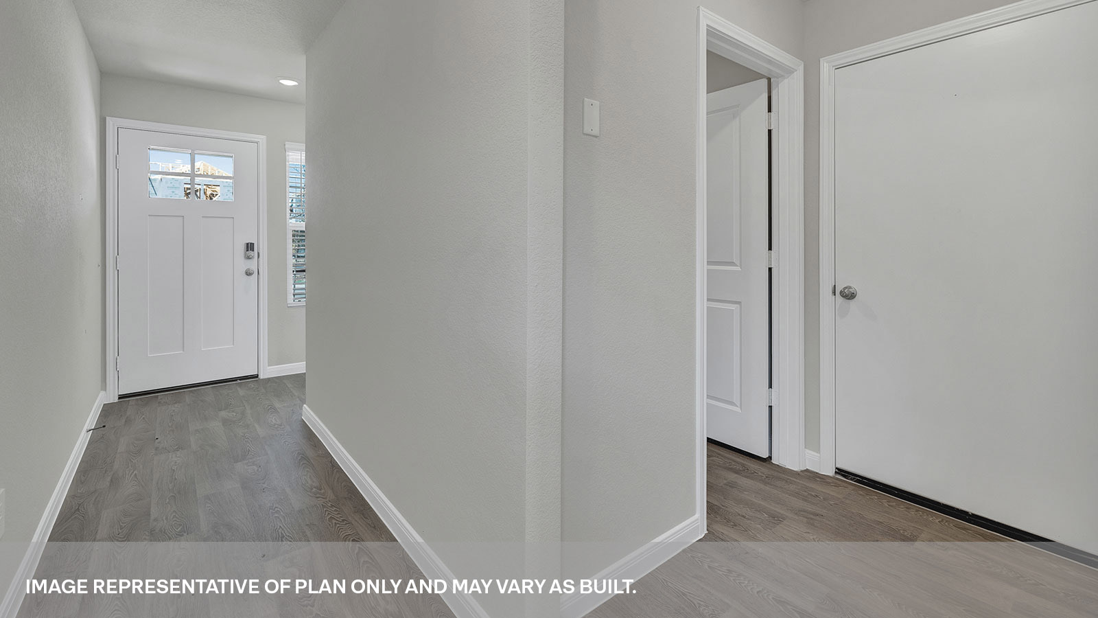 Entry hallway with vinyl flooring and front door.