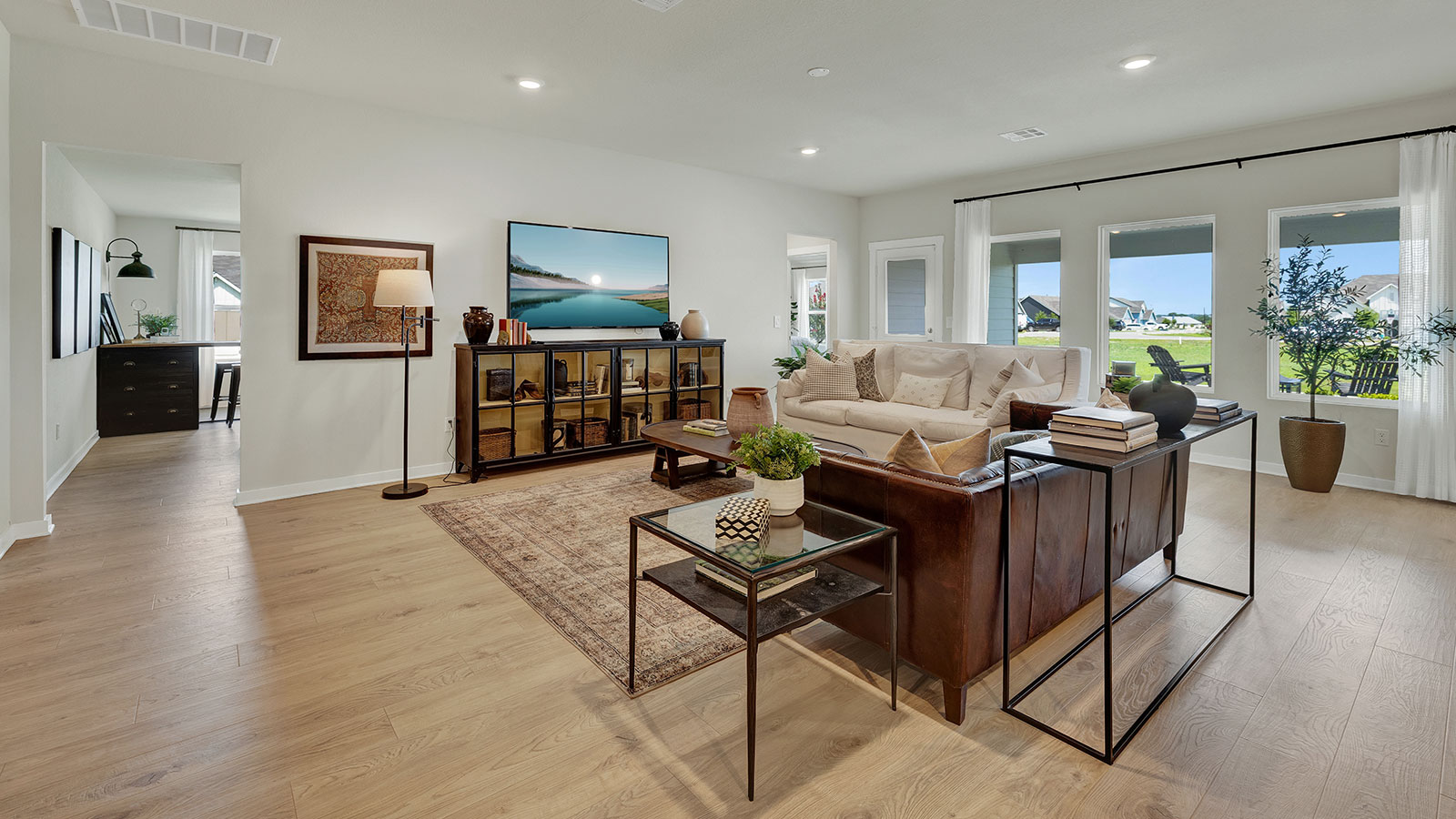 Living room with vinyl flooring and two windows.
