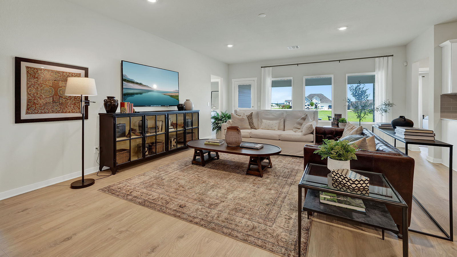 Living room with vinyl flooring and two windows.