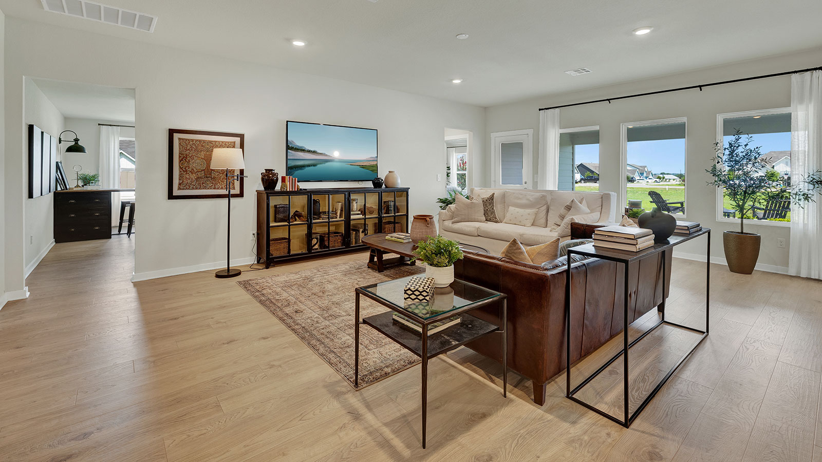 Living room with vinyl flooring and two windows.