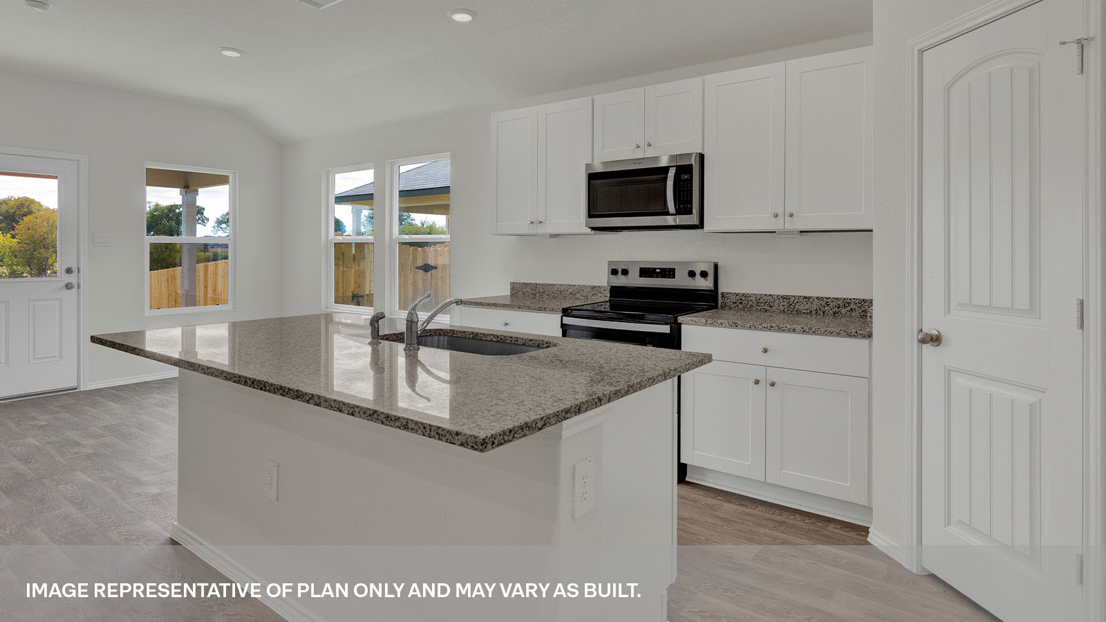 Large kitchen island with granite countertops open to the dining area and 2 large windows.