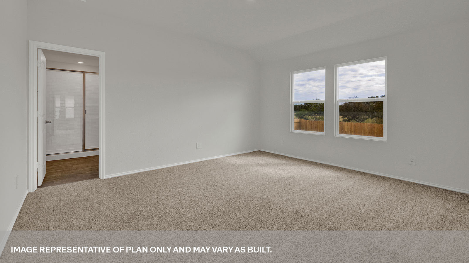Main bedroom with carpet and two windows.