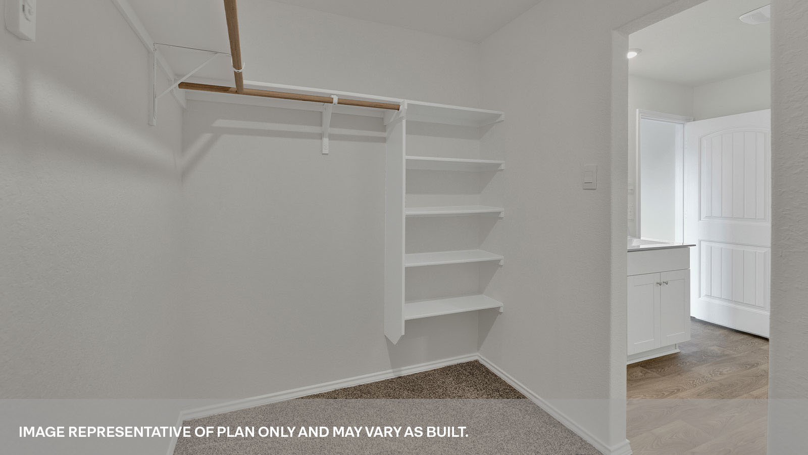 Walk-in closet with wooden shelves.