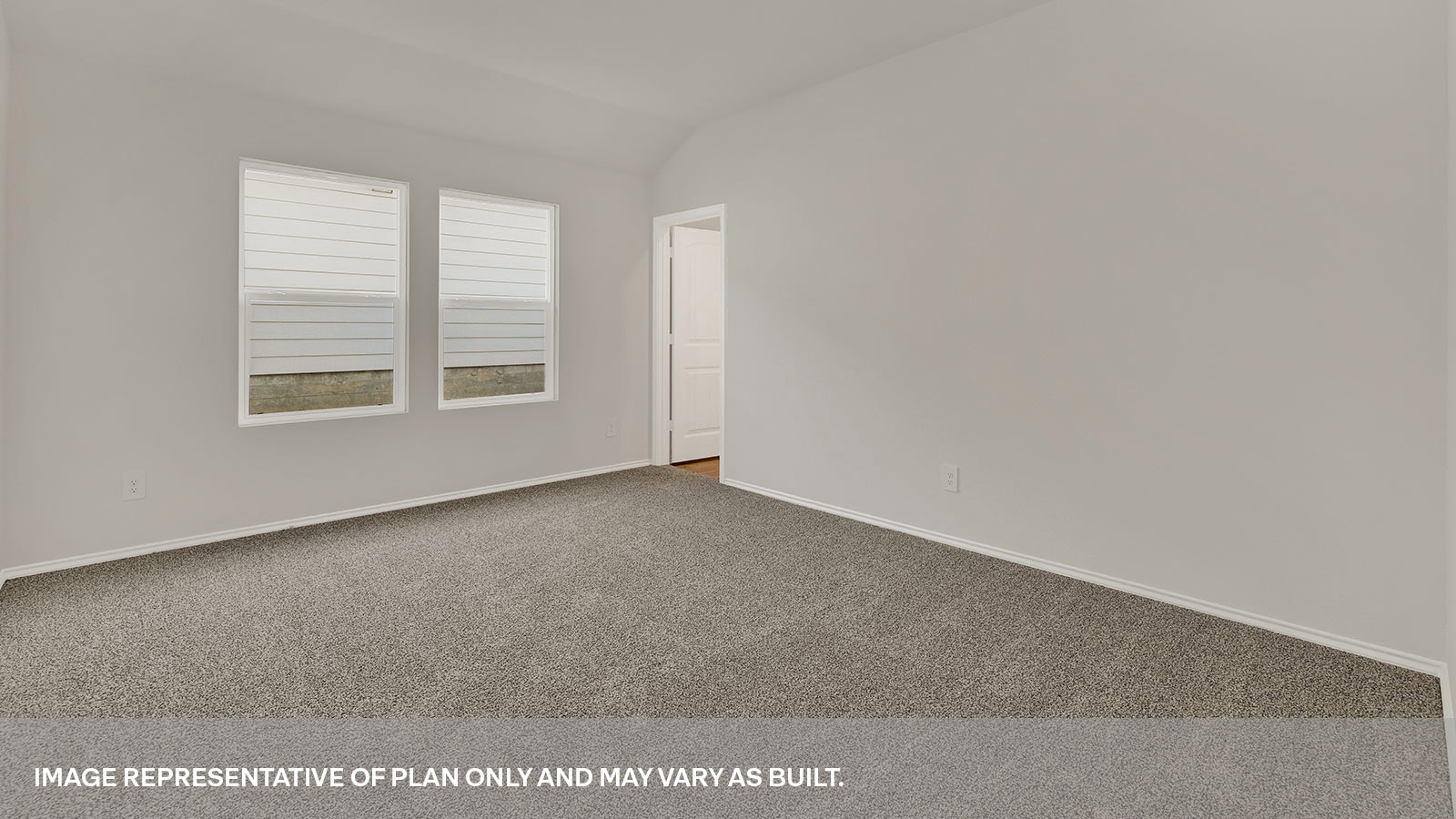 Main bedroom with carpet and two windows.