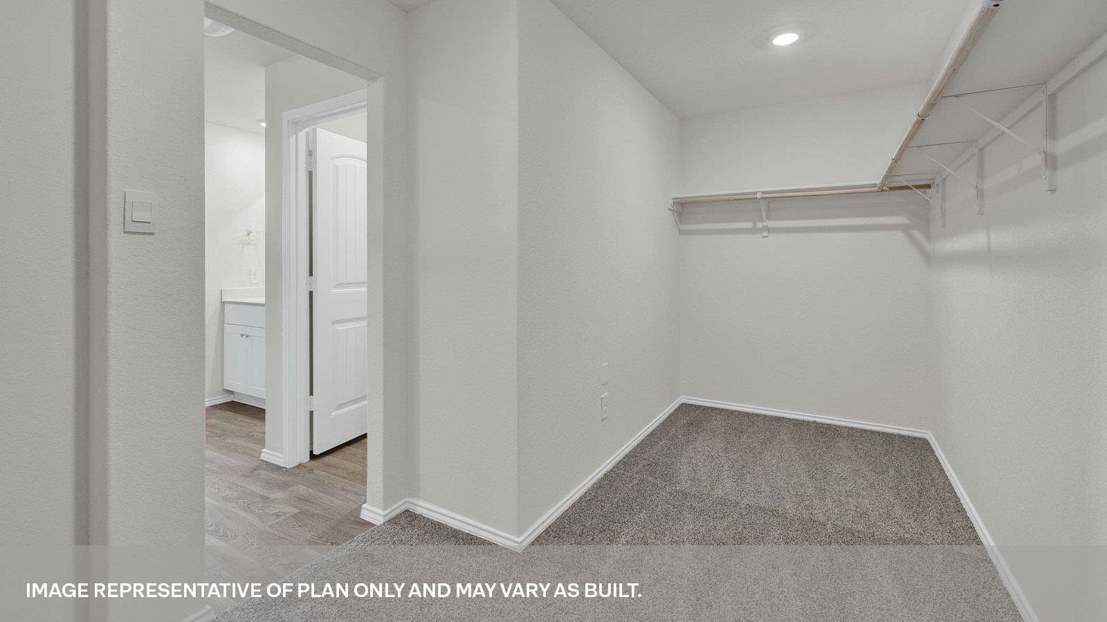 Closet with carpeting and wooden shelving.