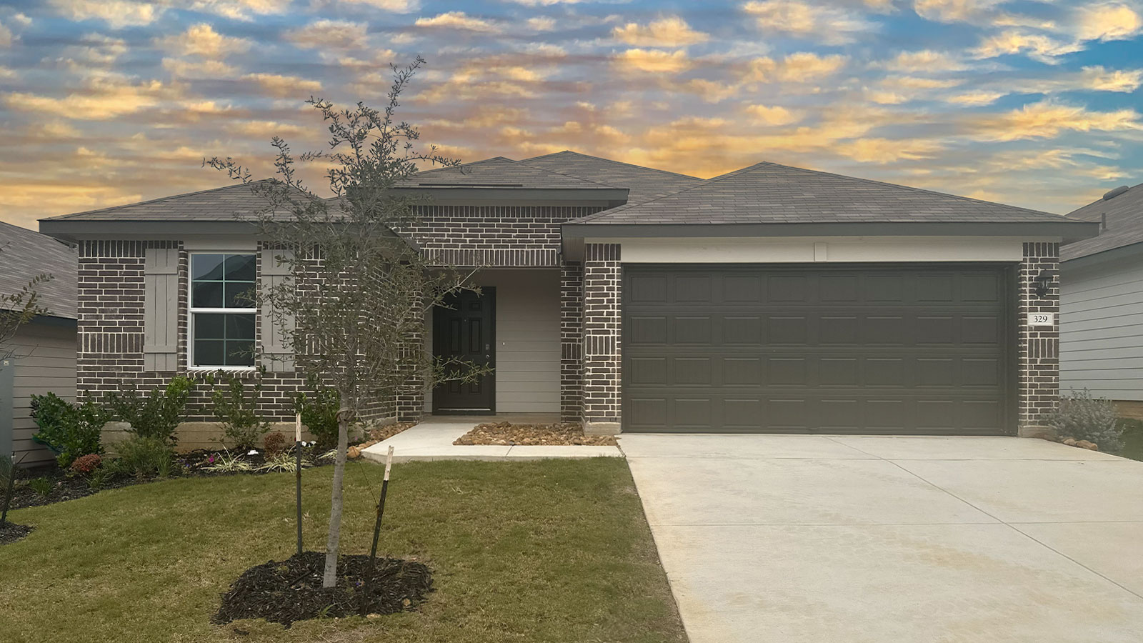 Single story home with brick, one window in the front, and a 2 car garage.