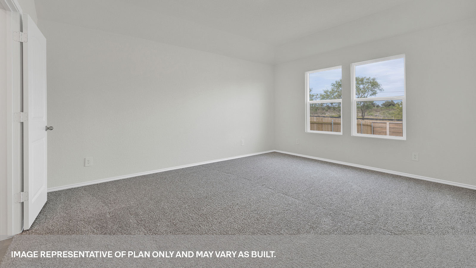 Main bedroom with carpeting and two windows.